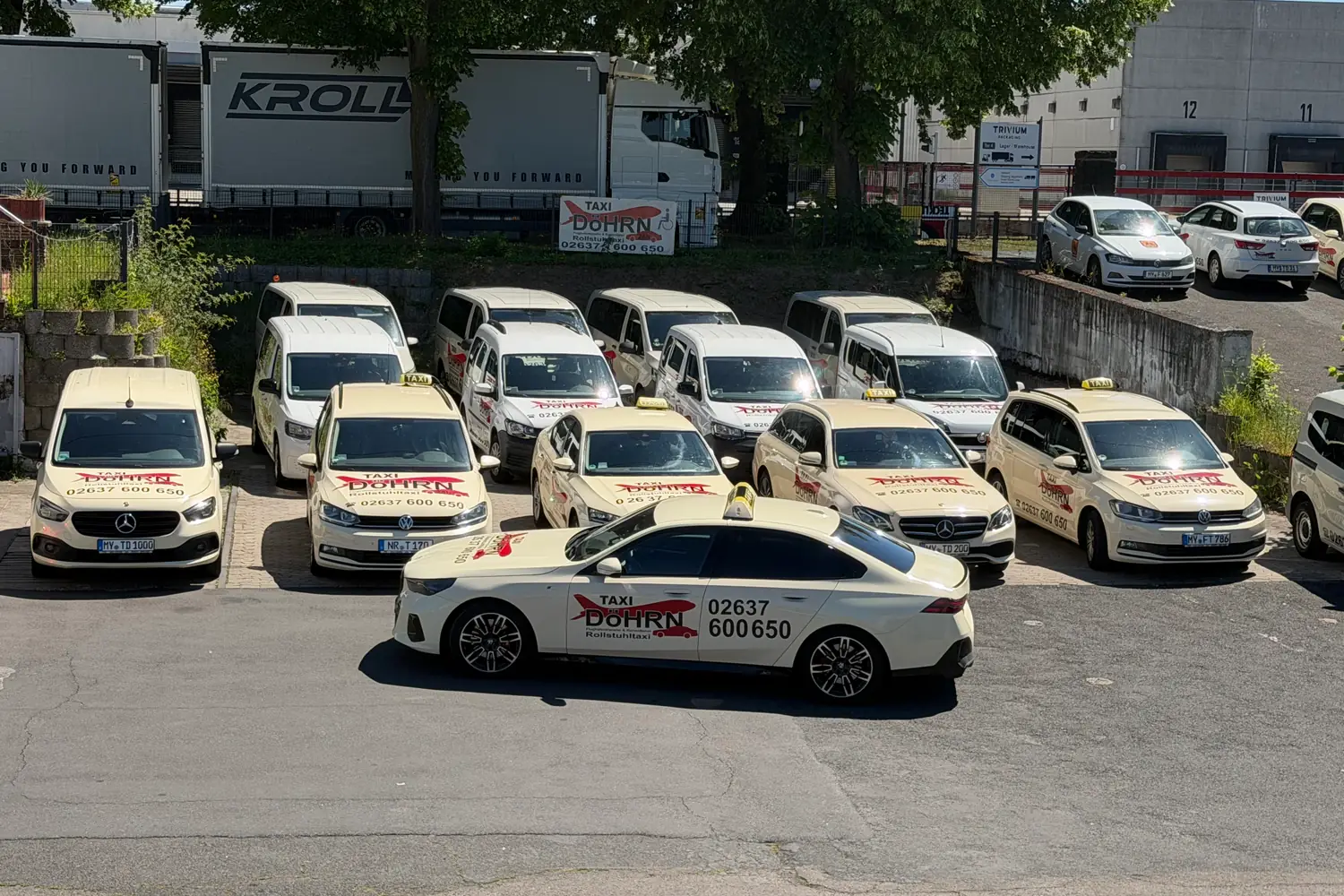 Dicht gestellte Taxiflotte von Taxi Döhrn mit rotem Schriftzug auf hellen Fahrzeugen