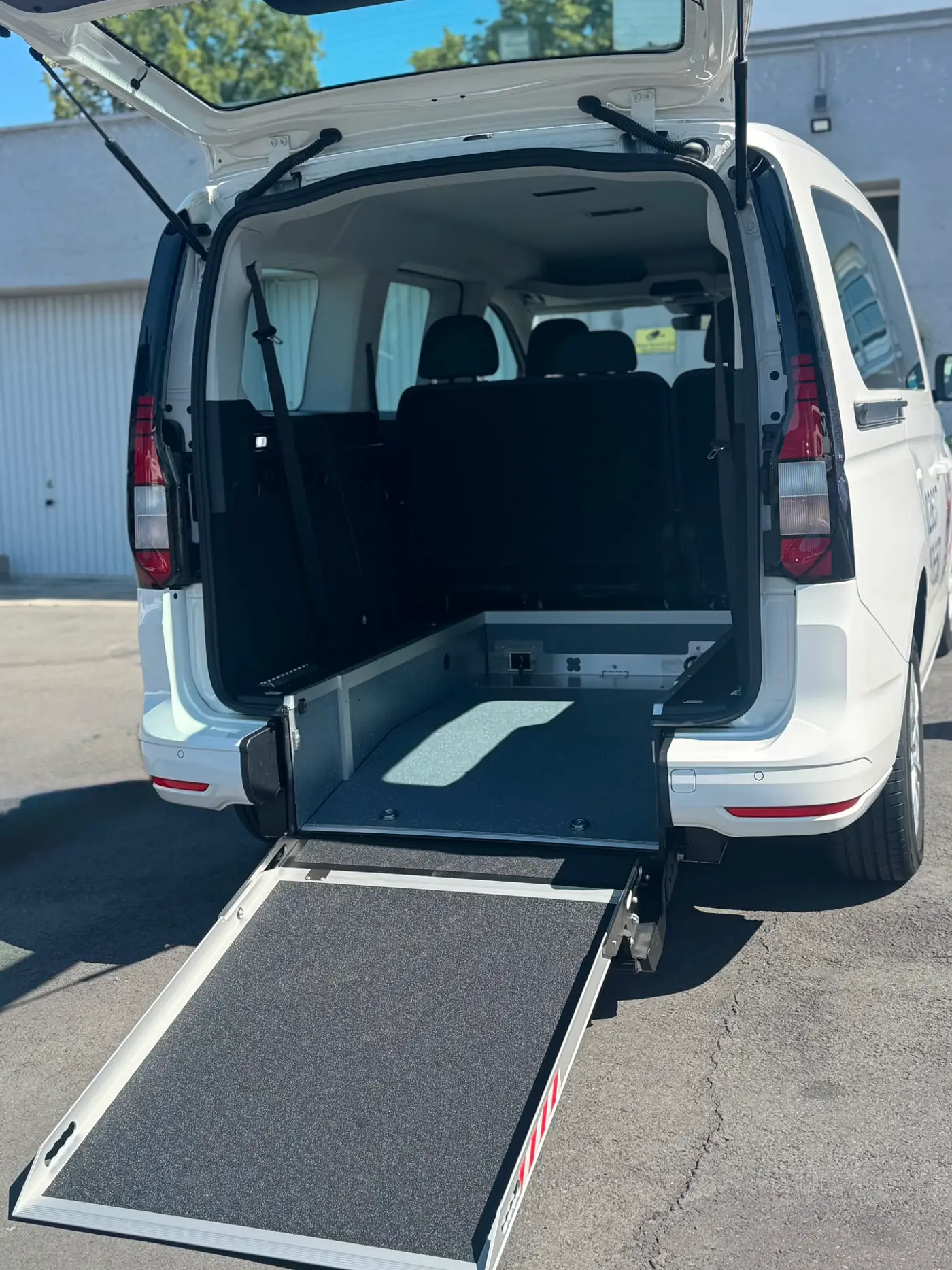Ausgeklappte Rollstuhlrampe am Heck eines Fahrzeugs von Taxi Döhrn, bereit zum Einfahren